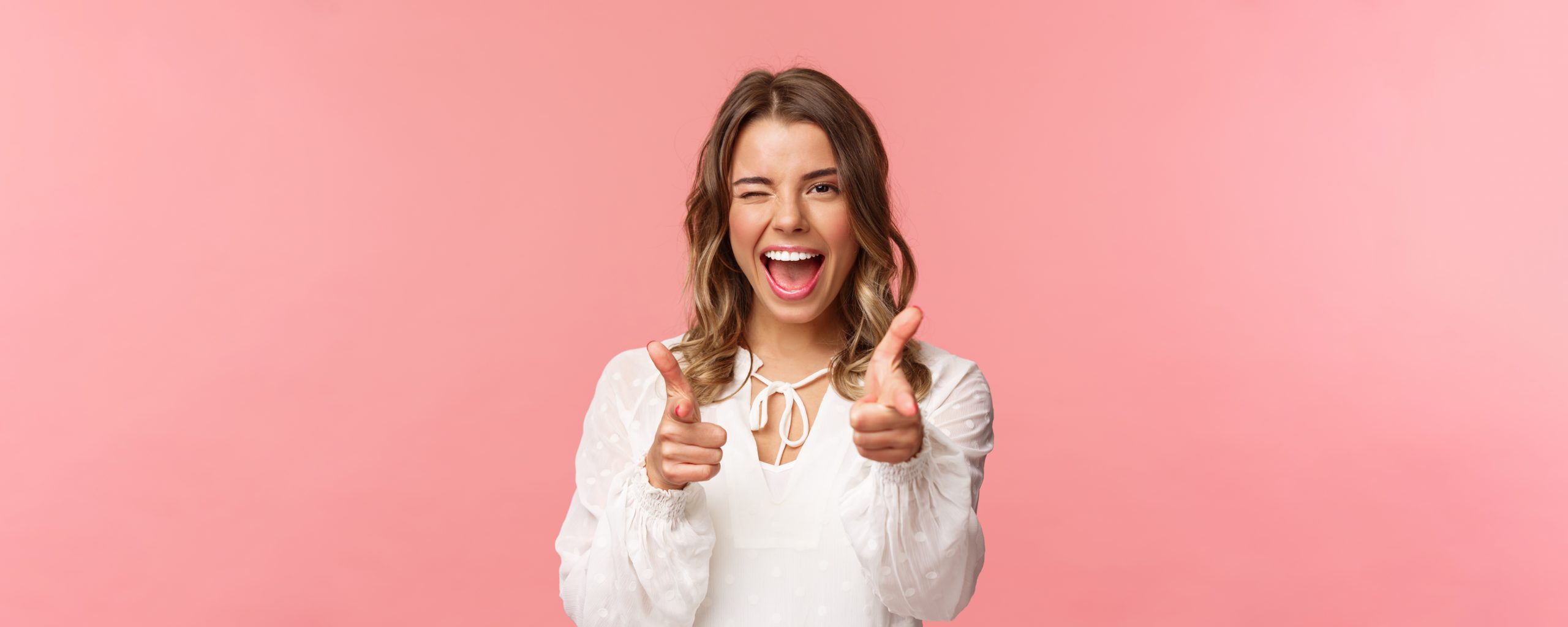 Close-up portrait of sassy and carefree good-looking emotive blond girl, pointing finger pistols at camera as asking join her team, become member, inviting try product yourself, smiling cheeky